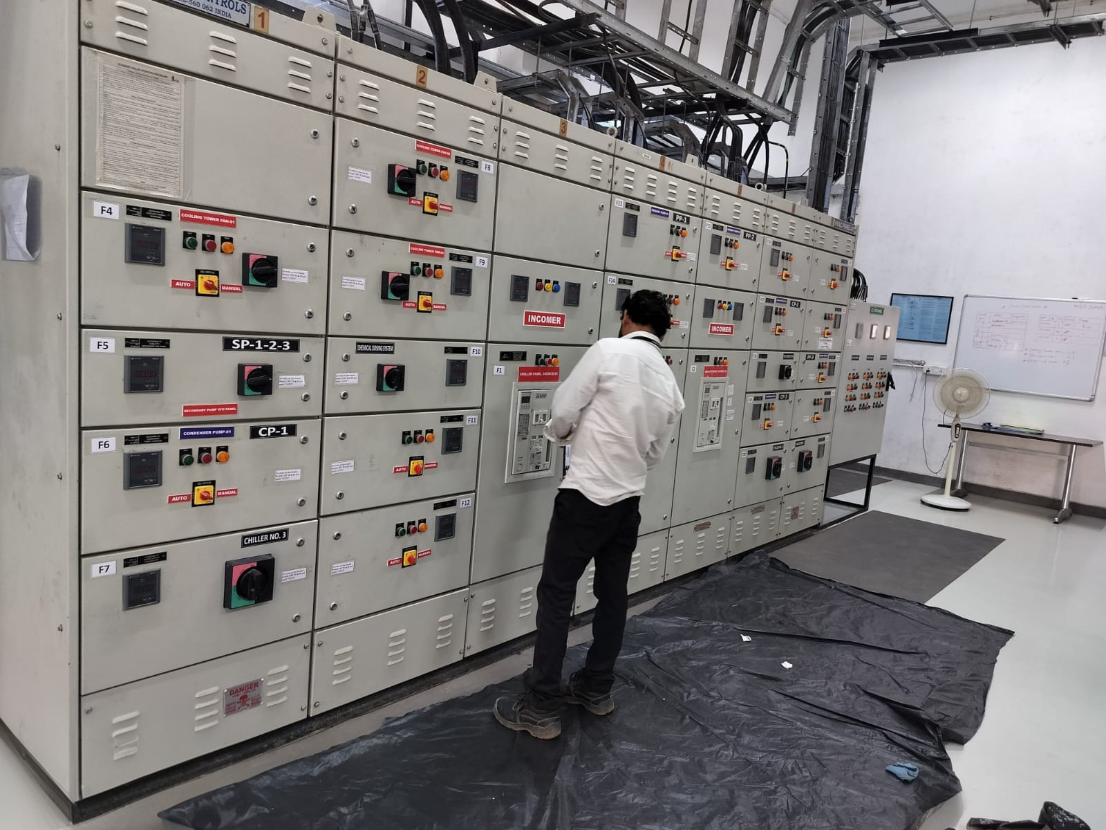 Electrical control panels with a technician inspecting the installation